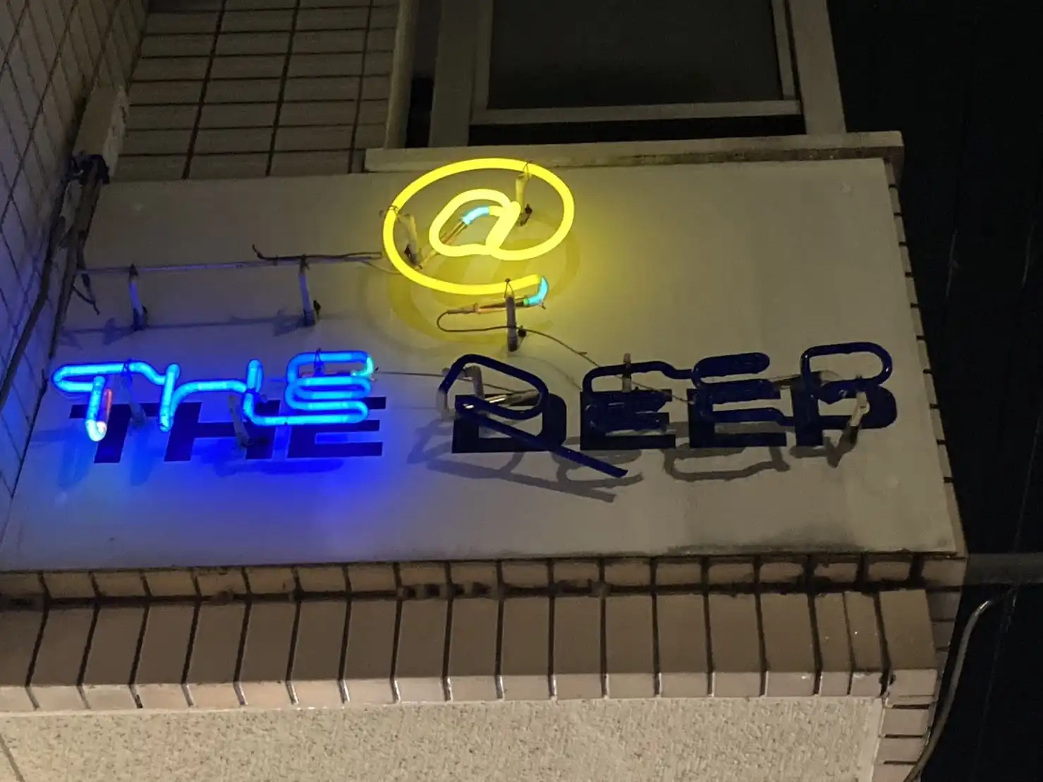 奈良市 新大宮駅から徒歩約7分の所に位置するbar @ the deepのネオンの看板です。@のもじが黄色theの文字が青く光っています。