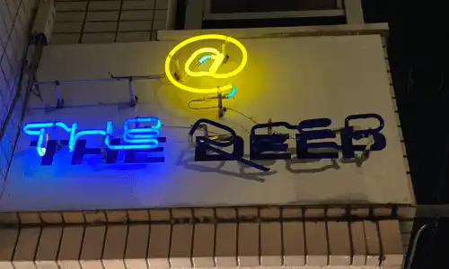 奈良市 新大宮駅から徒歩約7分の所に位置するbar @ the deepのネオンの看板です。@のもじが黄色theの文字が青く光っています。